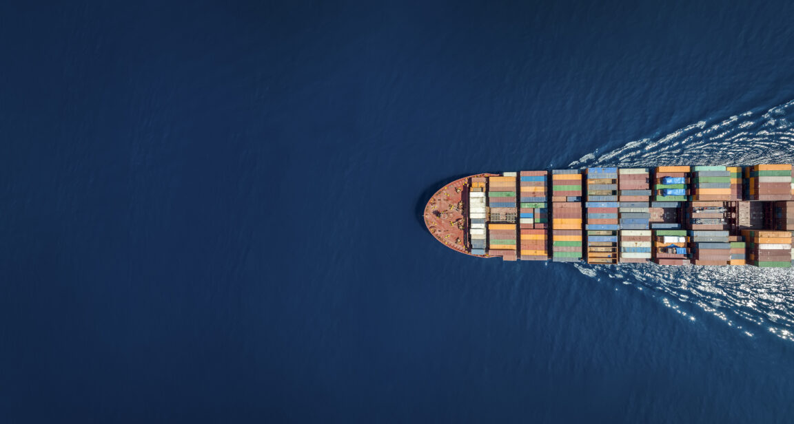 Front of a freight ship speeds through water