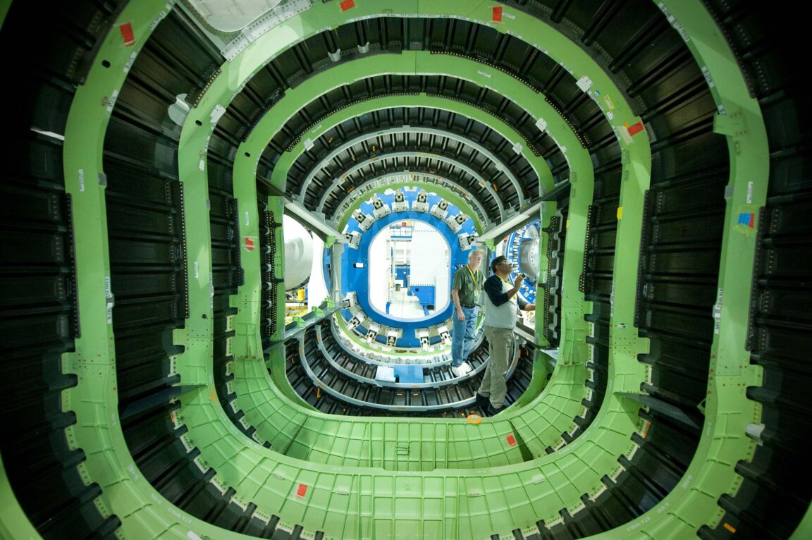 Two employees inspect the inside of an aircraft shell